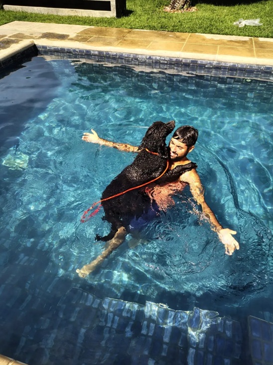 Eduardo nadando com cão na piscina